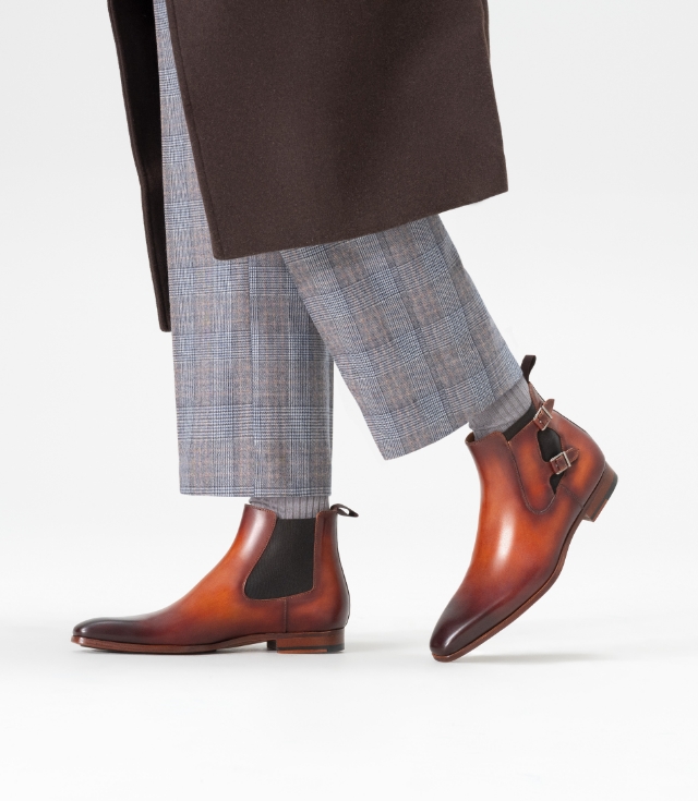 The Caspe Cognac is a luxurious chelsea boot featuring an elegant double monk strap and a meticulously hand-painted patina.