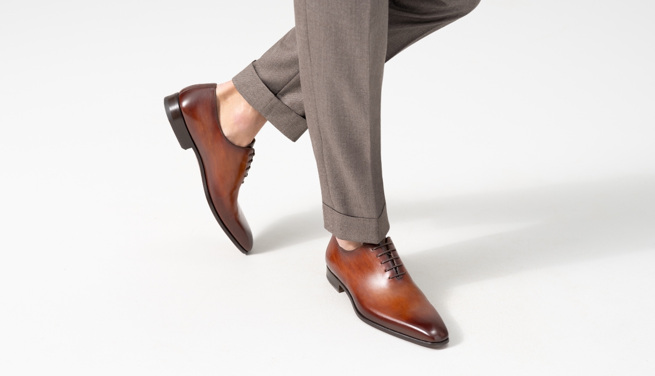 A man steps forward while wearing beige pants and Magnanni Cruz Cognac lace-ups.