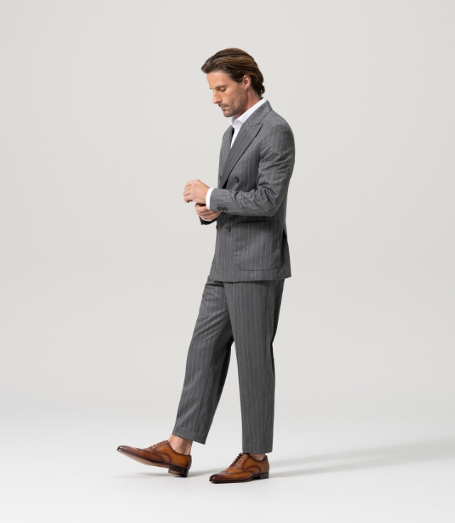 A man wears his Magnanni Minos Cuero dress lace-ups with a grey pinstriped suit.