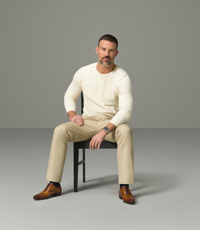 A male model looks at the camera while wearing a white shirt, khaki pants, and Magnanni Jaxton Cuero dress shoes.
