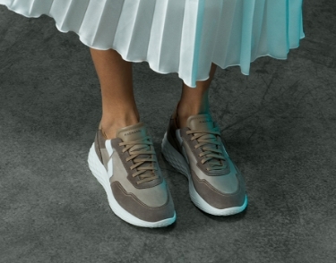 Close up of a woman wearing Magnanni Aero Taupe sneakers.