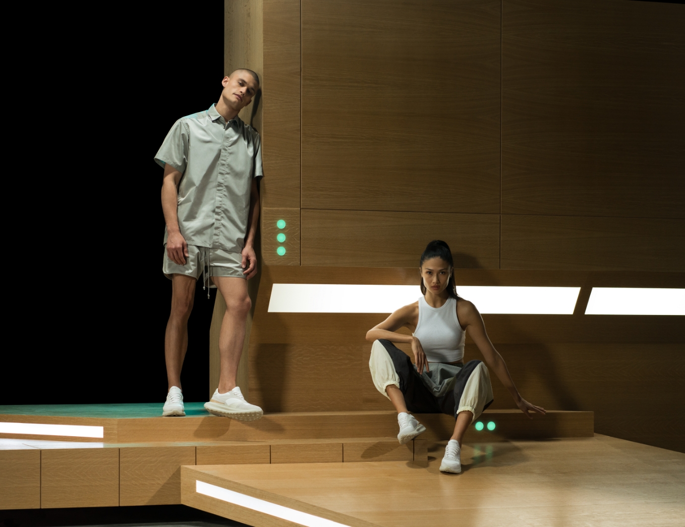 A man and woman pose on a wooden platform while wearing Magnanni Astro White sneakers.
